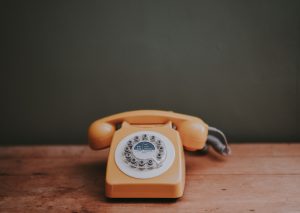 Vieux téléphone orange sur une table en bois