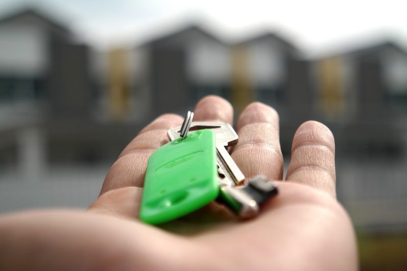 Agent immobilier qui tient les clés d'une maison dans sa main